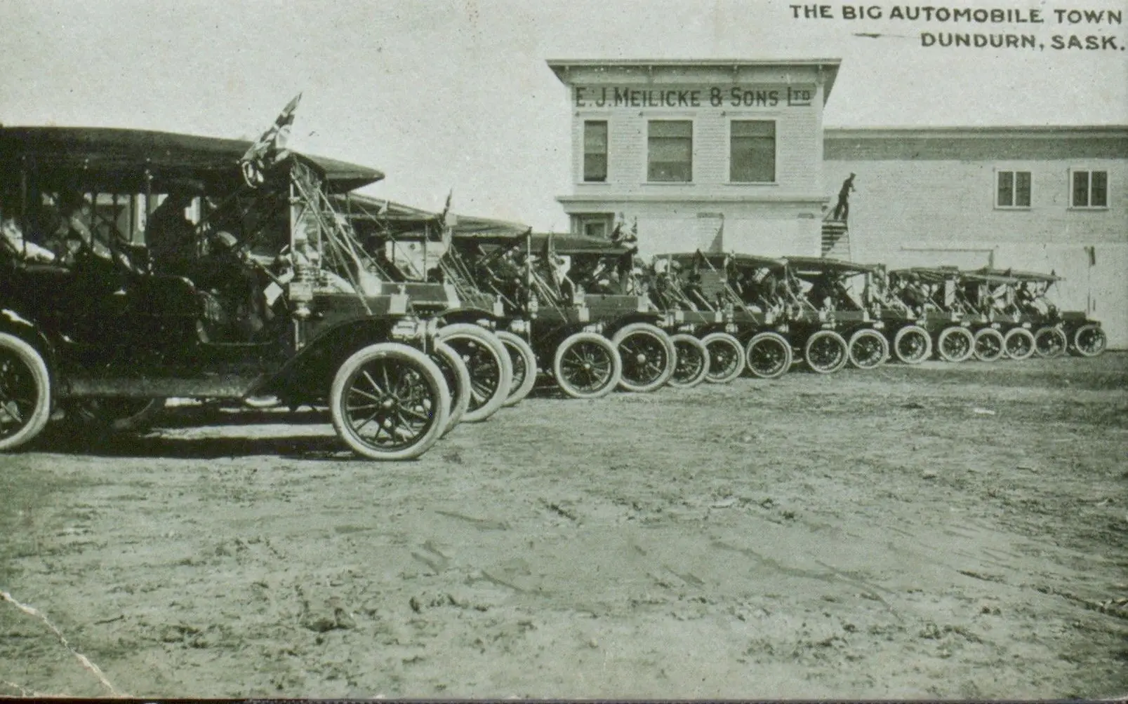 Row of early automobiles outside E.J. Meilicke & Sons Ltd., Dundurn